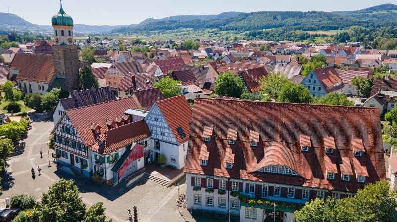 Am 1. Oktober 2025 findet eine Informationsveranstaltung für Neubürger statt. Eine Luftaufnahme von älteren Gebäuden